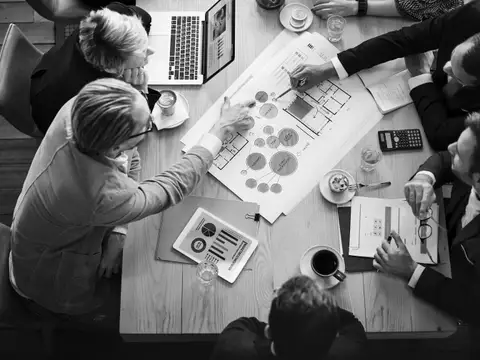 Geschäftstreffen mit Plänen und Diagrammen am Tisch