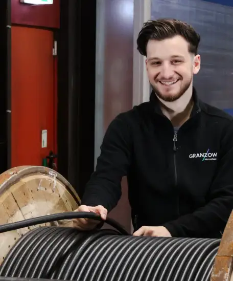 Exklusives Kabellager mit 800 Kabeln, freundlicher Mitarbeiter im modernen Lagerumfeld.