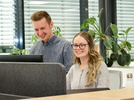 Mitarbeiter der Firma Ernst Granzow aus Bad Waldsee die zusammen am Computer arbeiten und dabei lachen.