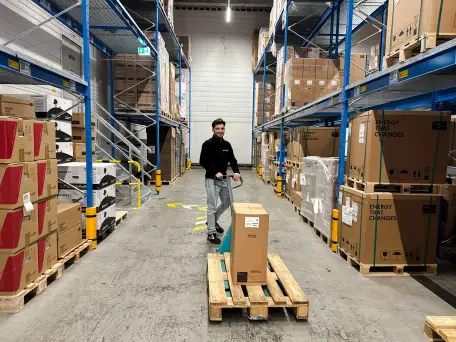 Ein Mitarbeiter der Firma Ernst Granzow in Leonberg der mit einer Palette voll Ware im Lager unterwegs ist.