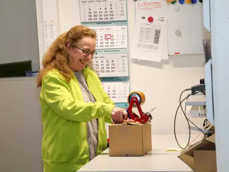 Mitarbeiterin der Firma Ernst Granzow in Leonberg die im Lager ein Paket verpackt.
